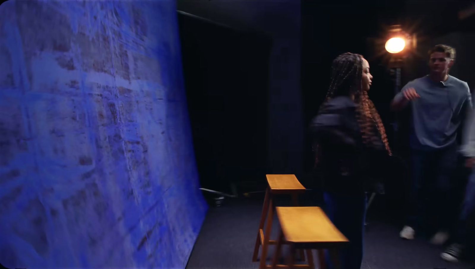 a man and a woman standing in front of a blue wall