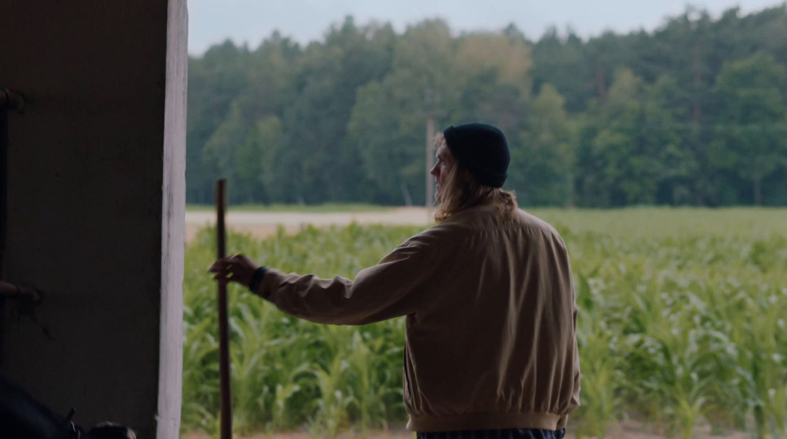 a man standing in front of a corn field