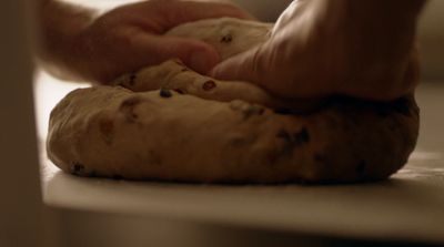 a person is kneading a doughnut on a counter