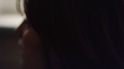 a close up of a woman's face with a cell phone in her hand
