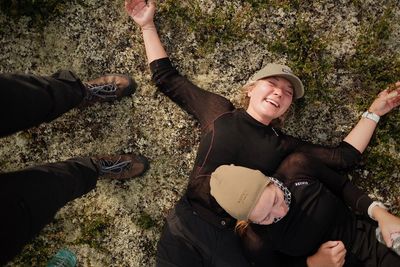 a couple of people laying on top of a grass covered field