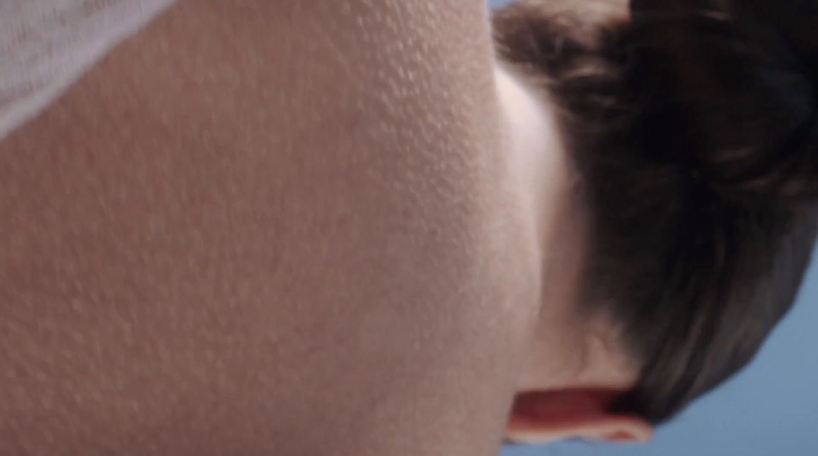 a close up of a woman's back with a hair bun