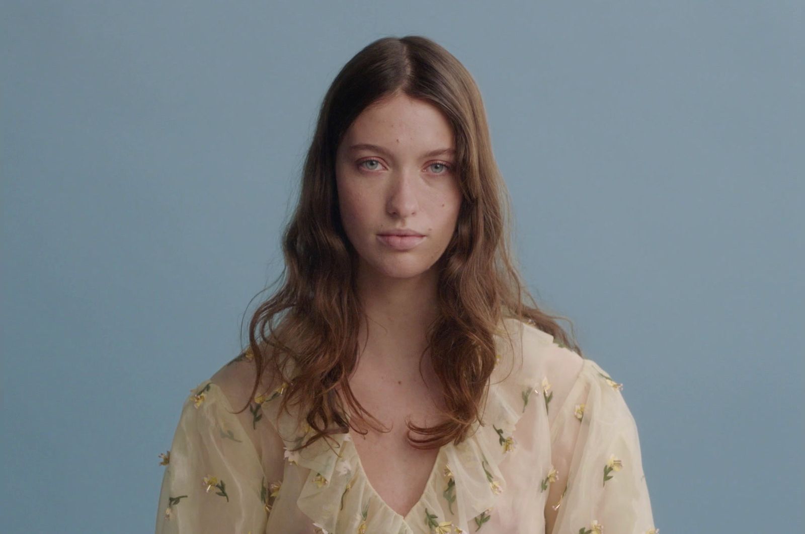 a woman with long hair wearing a blouse