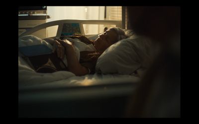 a woman laying in a hospital bed reading a book