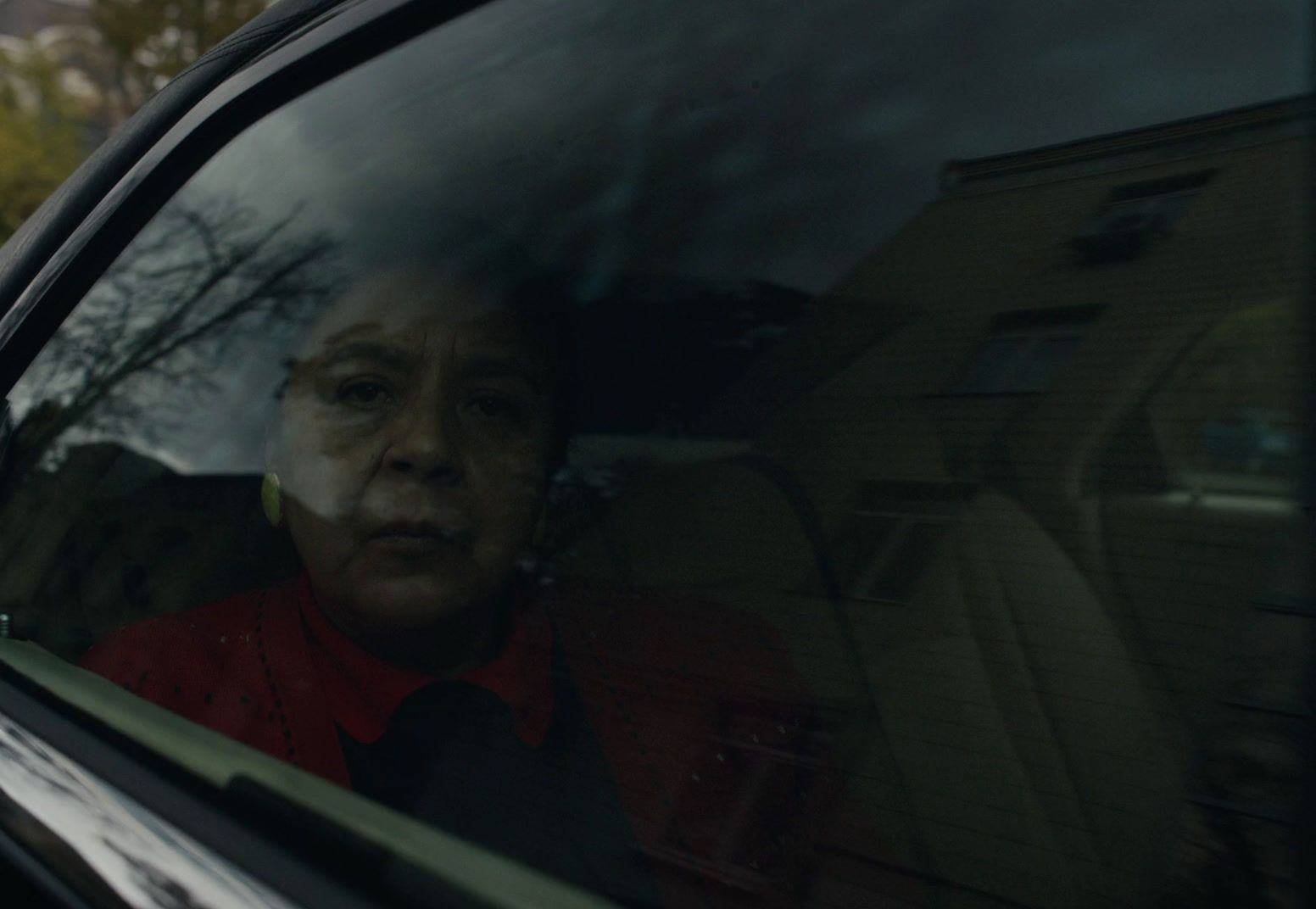 a woman sitting in a car looking out the window