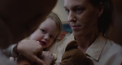 a woman holding a little girl who is holding a teddy bear