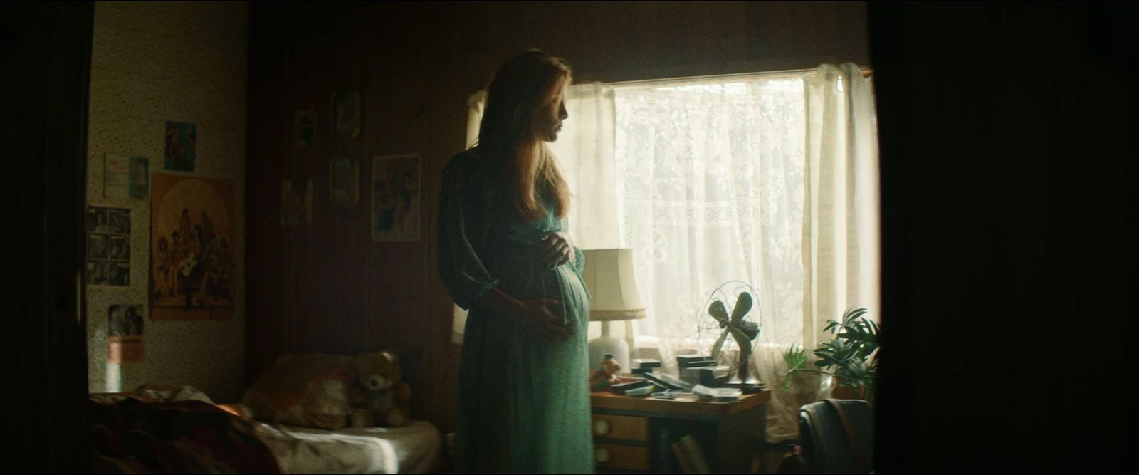 a woman in a green dress standing in a room