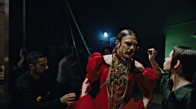 a group of people standing around a woman in a red dress