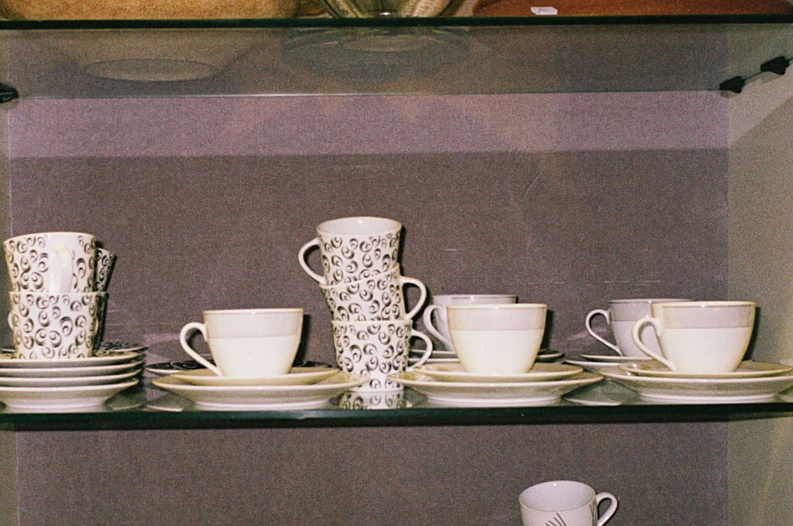 a shelf filled with lots of white cups and saucers