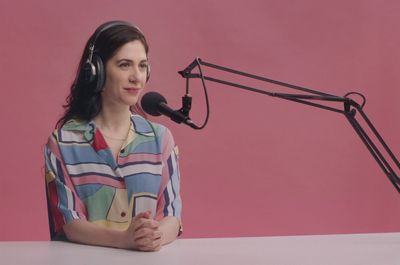 a woman wearing headphones sitting in front of a microphone