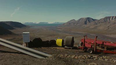 a red trailer sitting on top of a dirt field