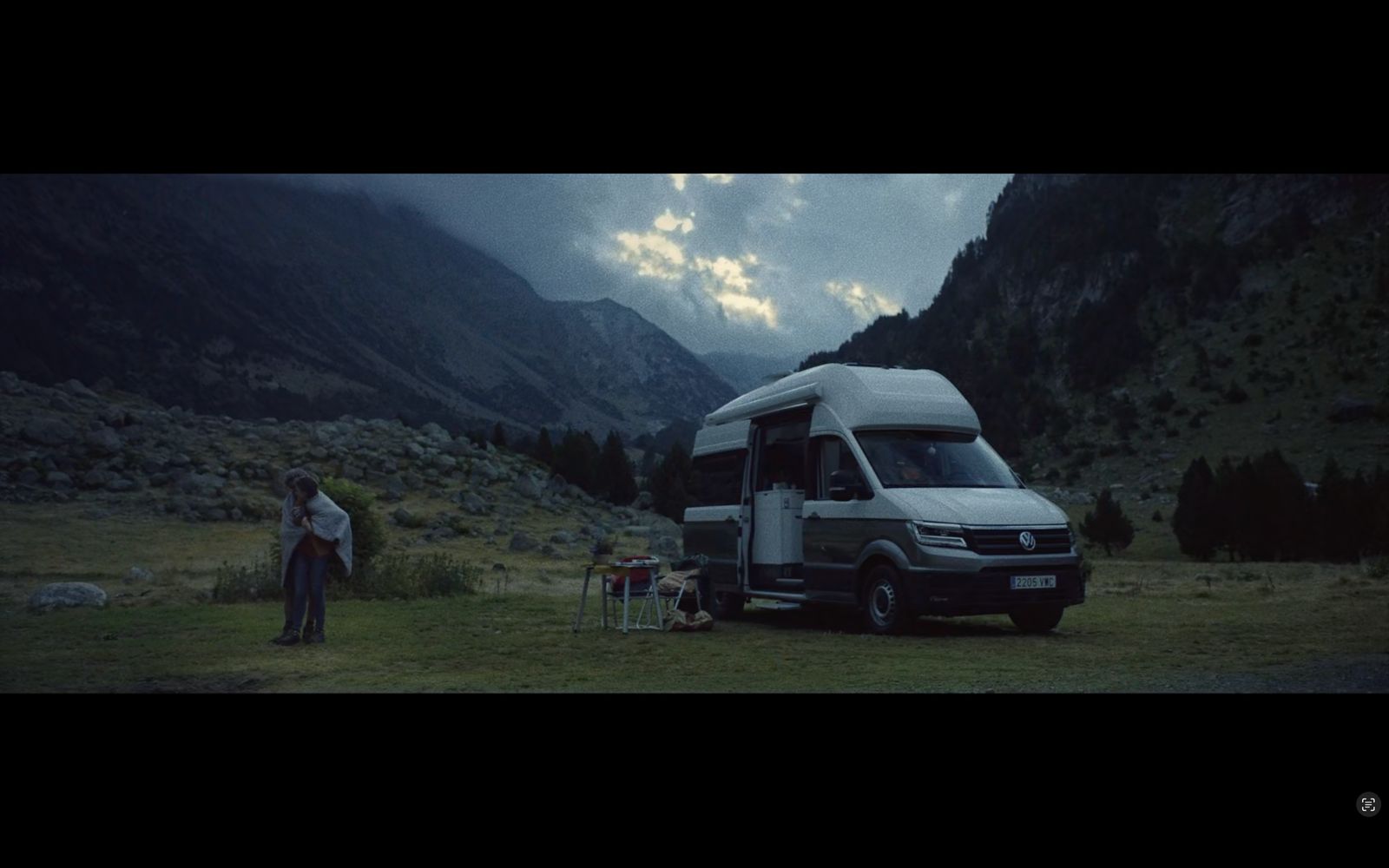 a person standing next to a van in the mountains