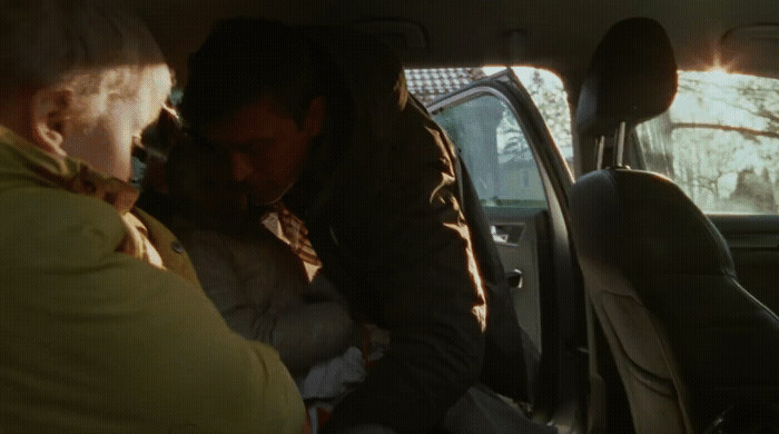 a man and a woman sitting in a car