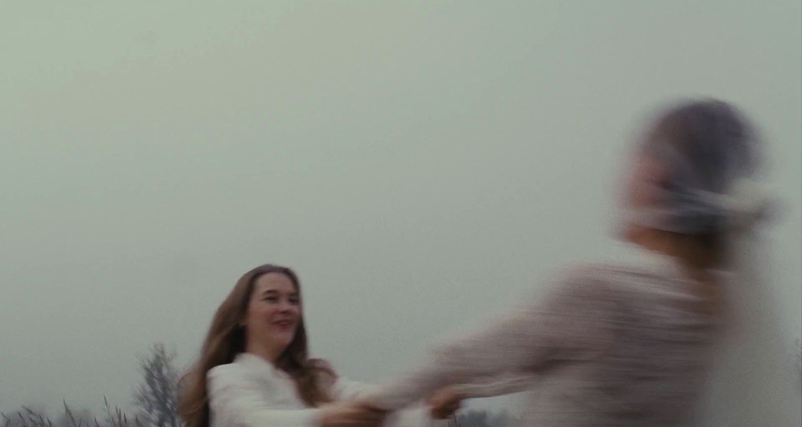 a blurry photo of a woman and a man holding hands
