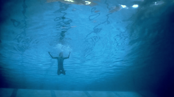 a person swimming under water in a pool