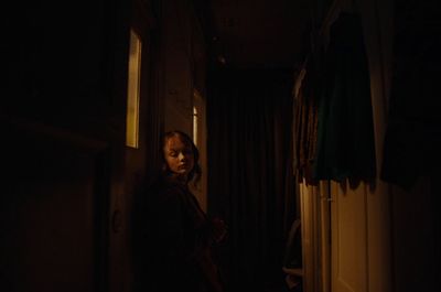 a woman standing in a doorway at night