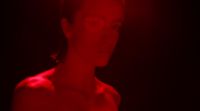 a woman standing in a dark room with a red light