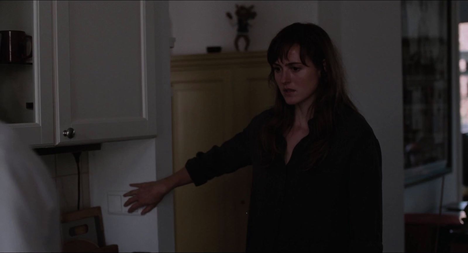 a woman standing in a kitchen with her hand out