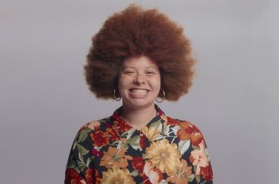 a woman with an afro smiling for the camera