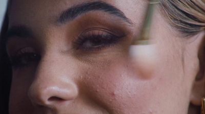 a close up of a woman's face with a pair of scissors in her