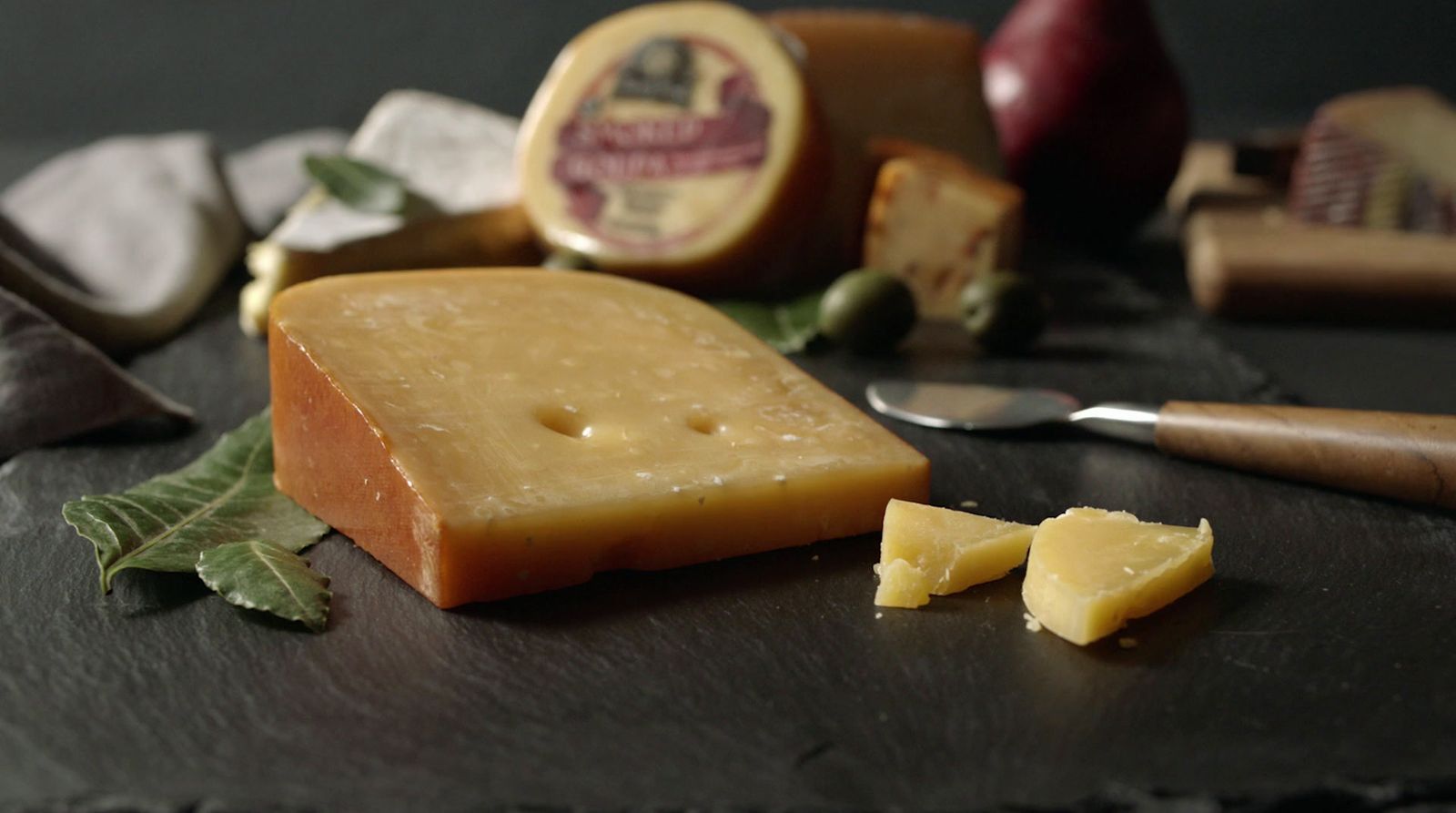 a piece of cheese sitting on top of a table next to a knife