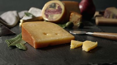 a piece of cheese sitting on top of a table next to a knife