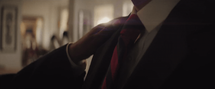 a man in a suit and tie standing in a room