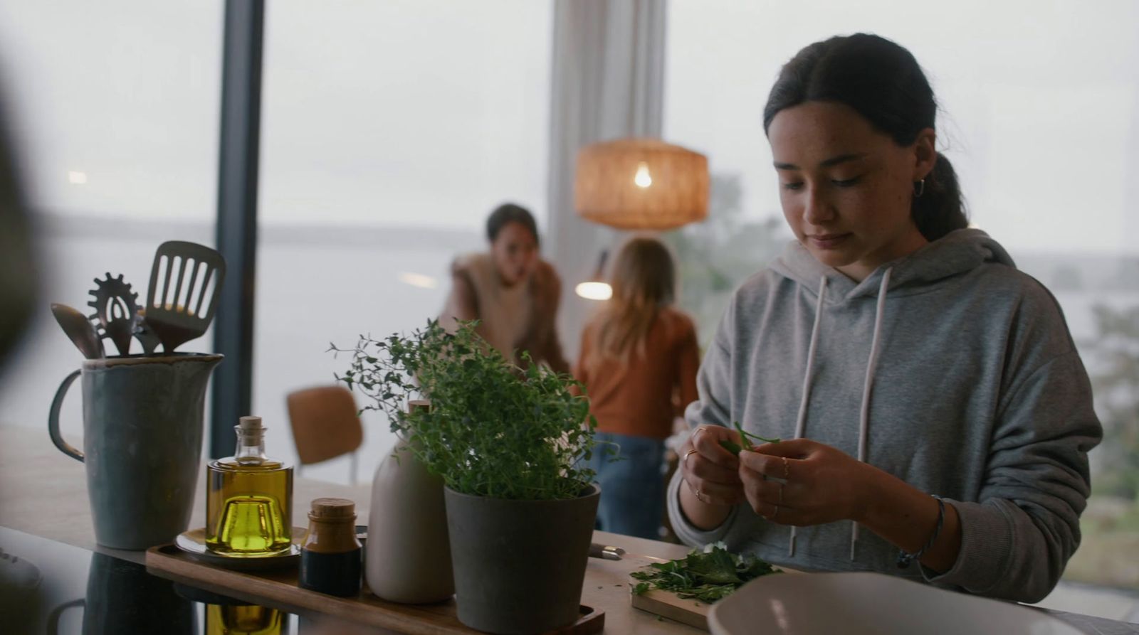 a woman standing in front of a counter with a potted plant