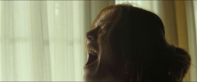 a woman standing in front of a window with her mouth open