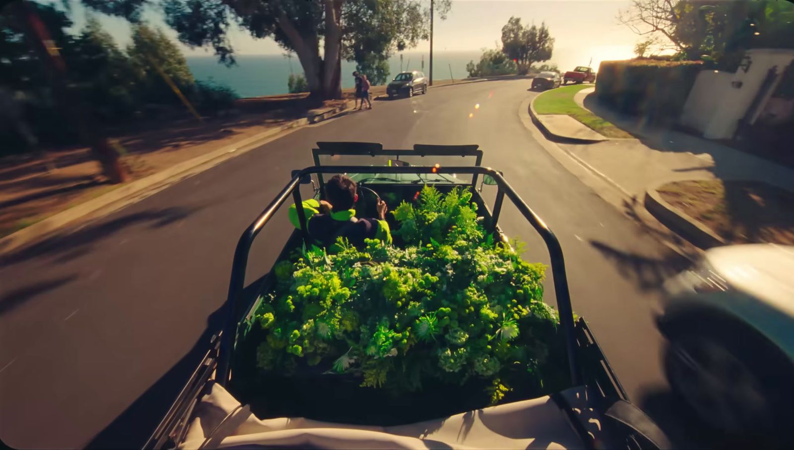 a truck filled with lots of lettuce driving down a street