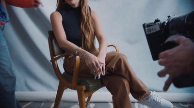 a woman sitting in a chair with a camera