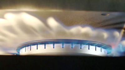 a close up of a stove with a blue flame