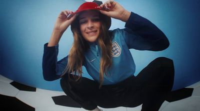 a woman sitting on the ground with a hat on her head