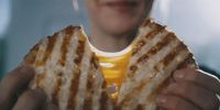 a close up of a person holding a sandwich