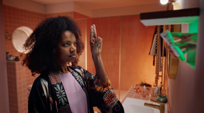 a woman standing in front of a bathroom mirror