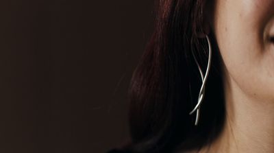 a close up of a person wearing a pair of earrings