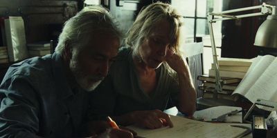 a man and a woman sitting at a table looking at a piece of paper