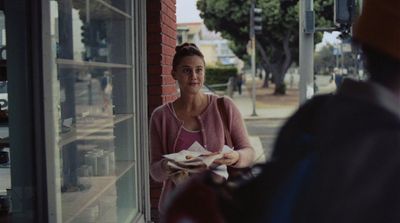 a woman holding a plate of food in front of a window
