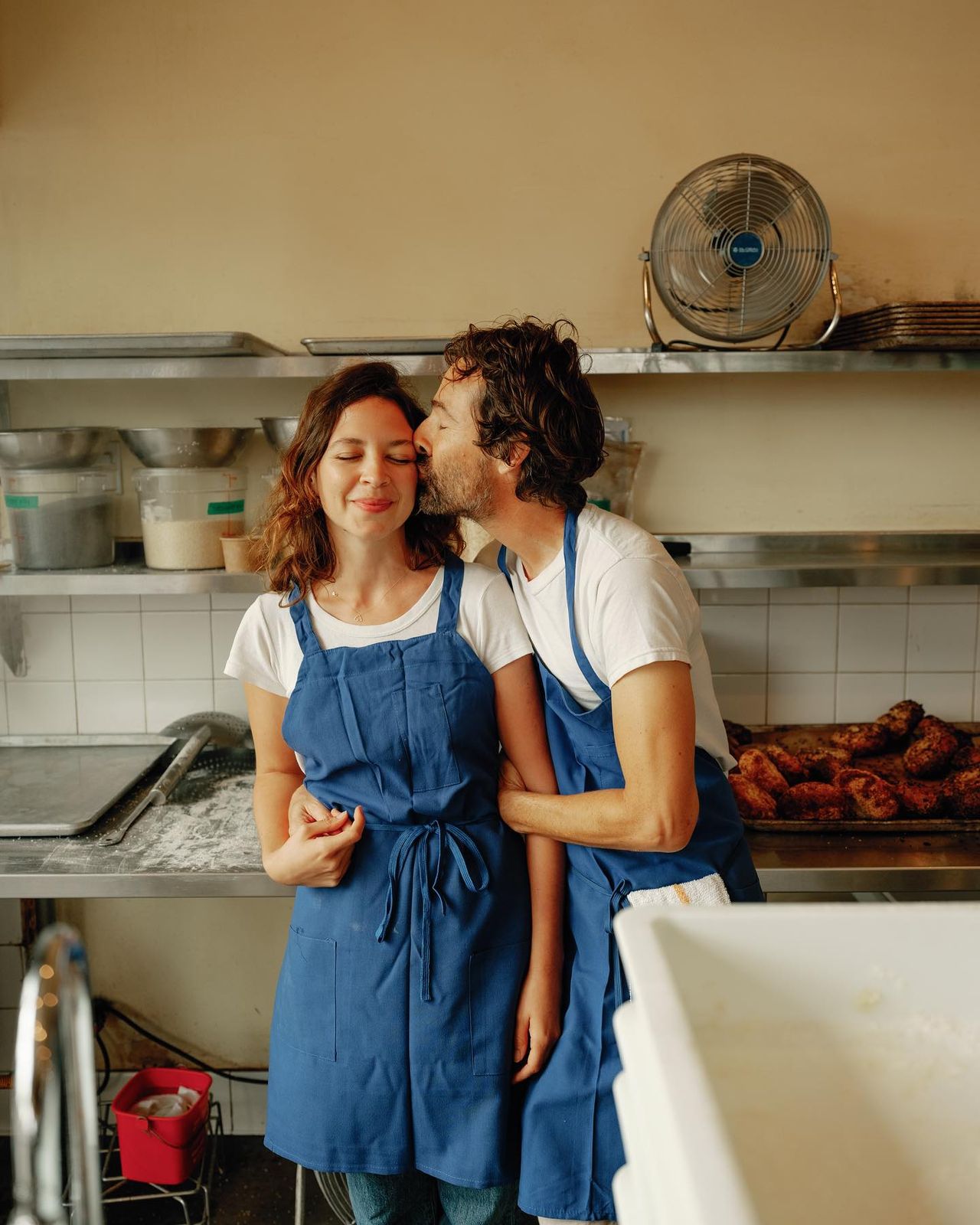 a man and a woman kissing in a kitchen