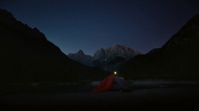 a tent pitched up in the mountains at night