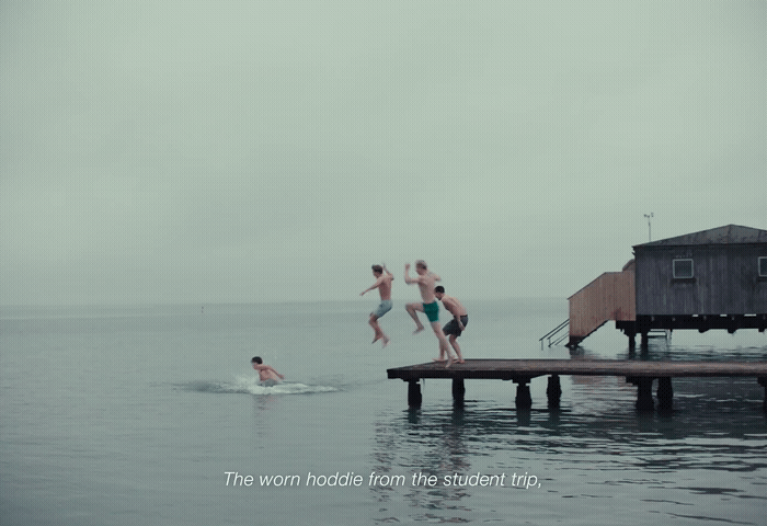 a group of people jumping off a dock into the water
