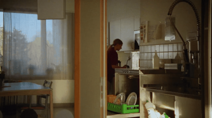 a man standing in a kitchen next to a sink