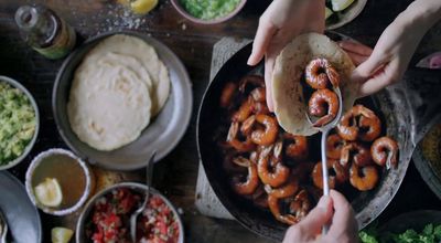 a table full of food and a person holding a spoon