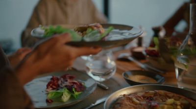 a group of people sitting around a table with plates of food