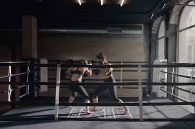 a couple of women standing next to each other in a boxing ring