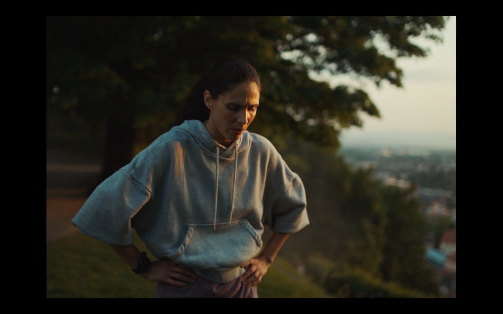 a woman standing in a field with her hands on her hips