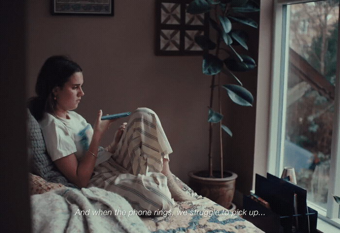 a woman sitting on a bed in front of a window