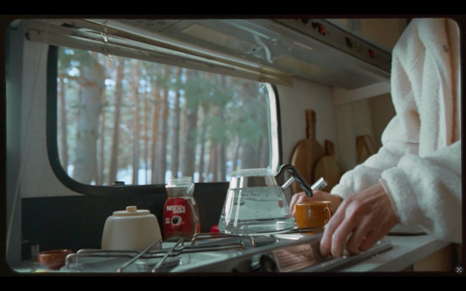 a person in a white robe preparing food in a kitchen