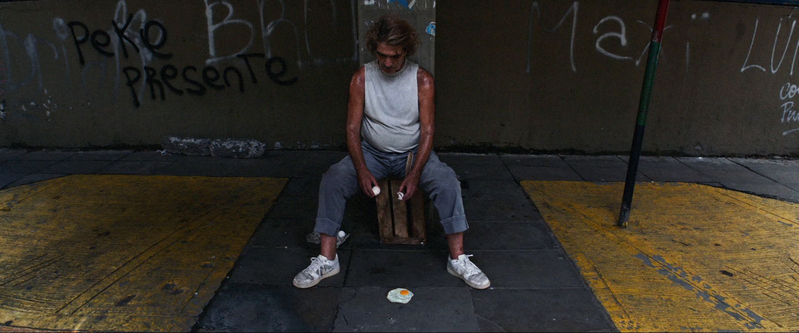 a man sitting on a chair on a sidewalk