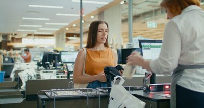 a woman paying something at a checkout counter